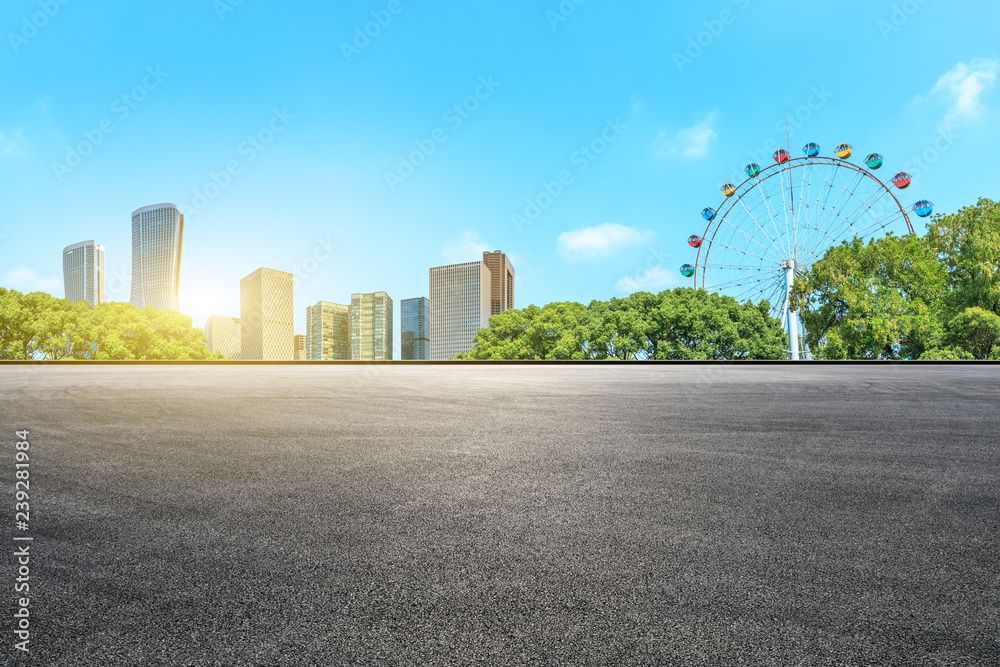 空的沥青路面和带摩天轮的现代建筑