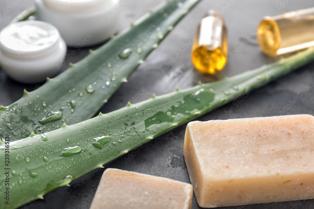 Cosmetic products with fresh aloe on grey table