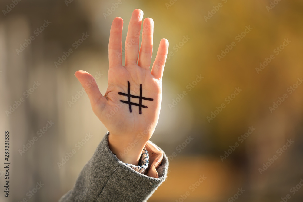 Woman with drawn hashtag sign on her hand outdoors