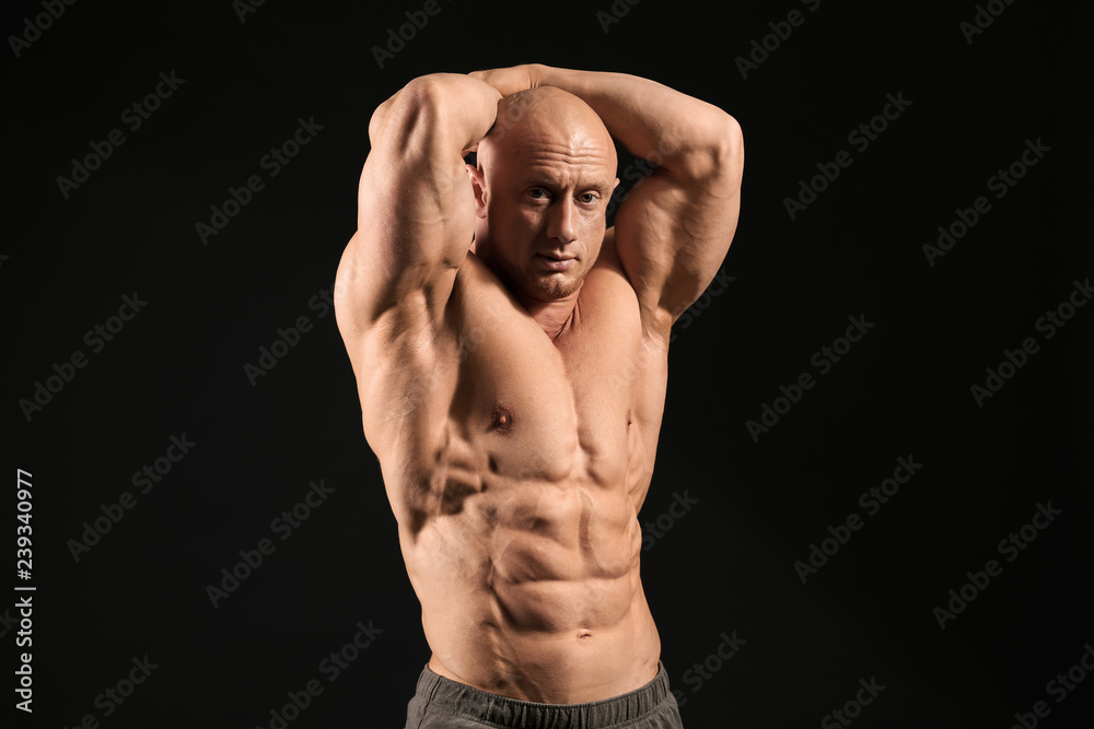 Muscular bodybuilder on dark background