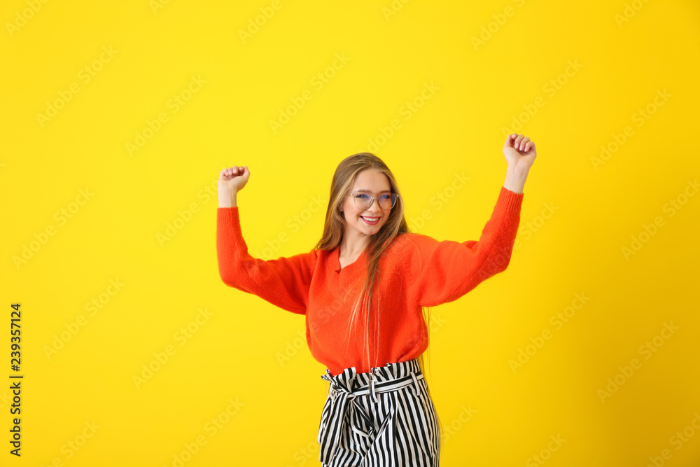 Beautiful young woman dancing on color background