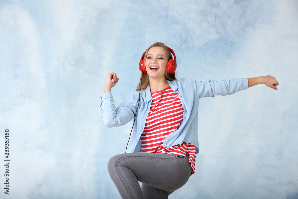 Beautiful young woman dancing on color background