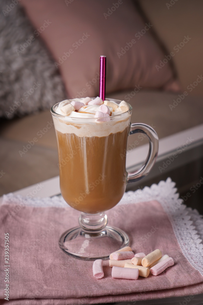 Glass cup of tasty frappe coffee with marshmallow on table