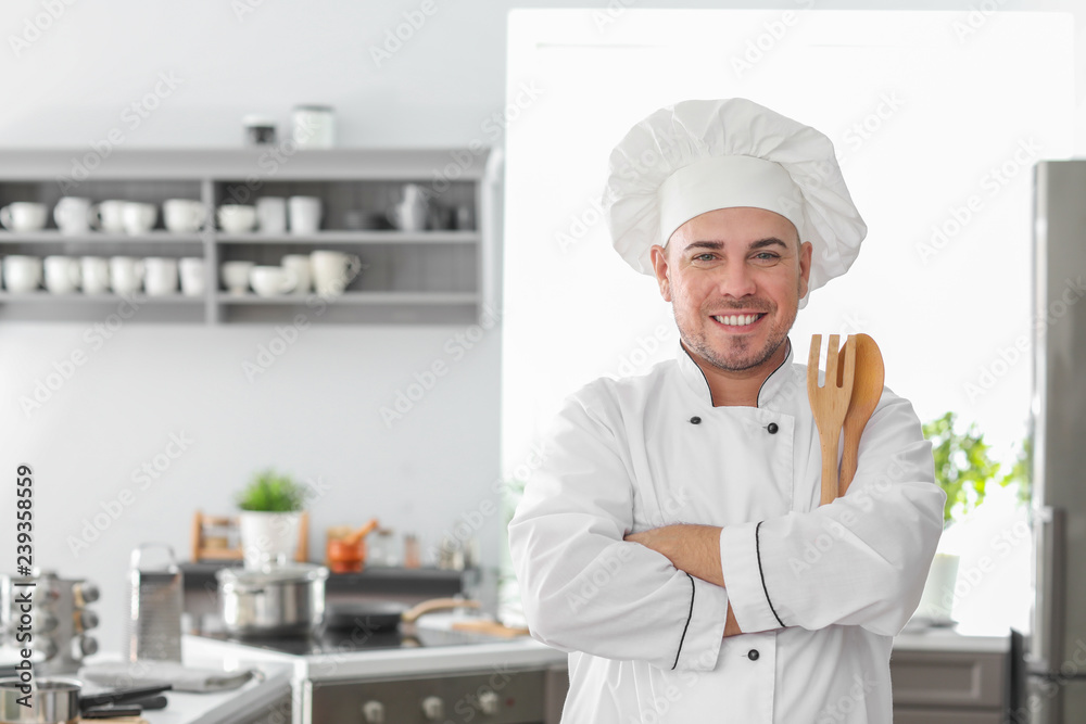 Male chef with utensils in kitchen