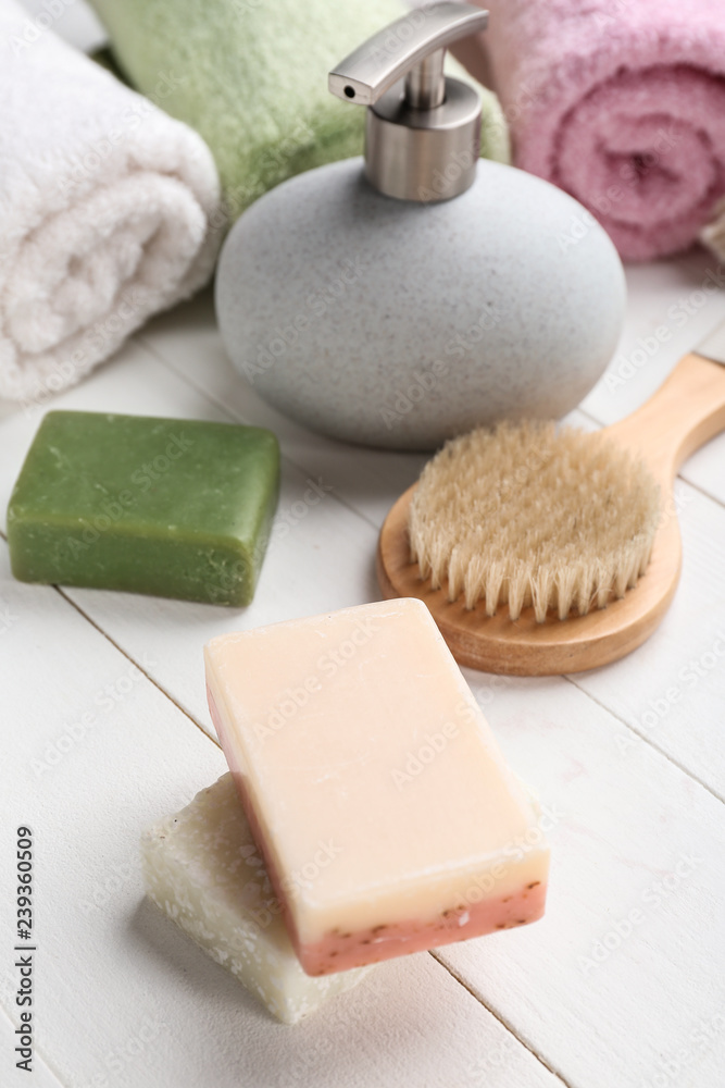 Soap, brush and towels on table in bathroom