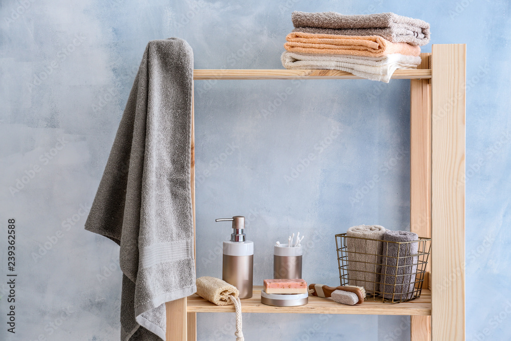 Soap, towels and body care cosmetics on shelf in bathroom