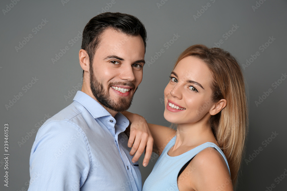 Stylish young couple on grey background