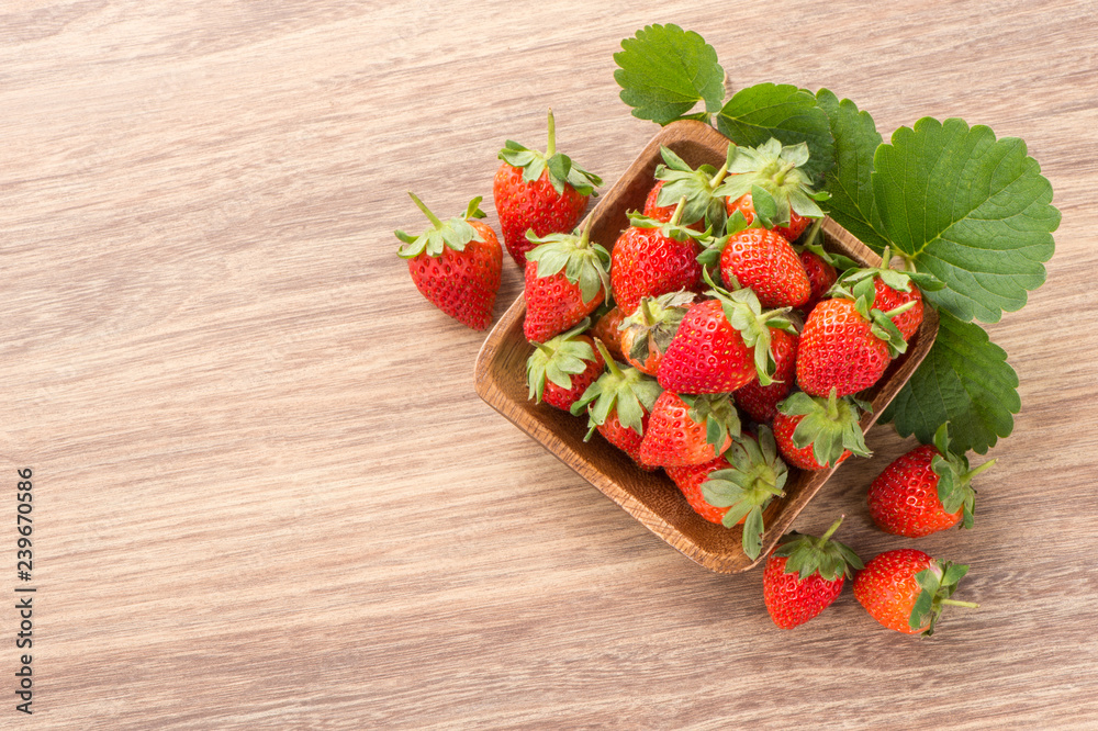 A plate of beautiful strawberries isolated on wooden background, close up, macro.