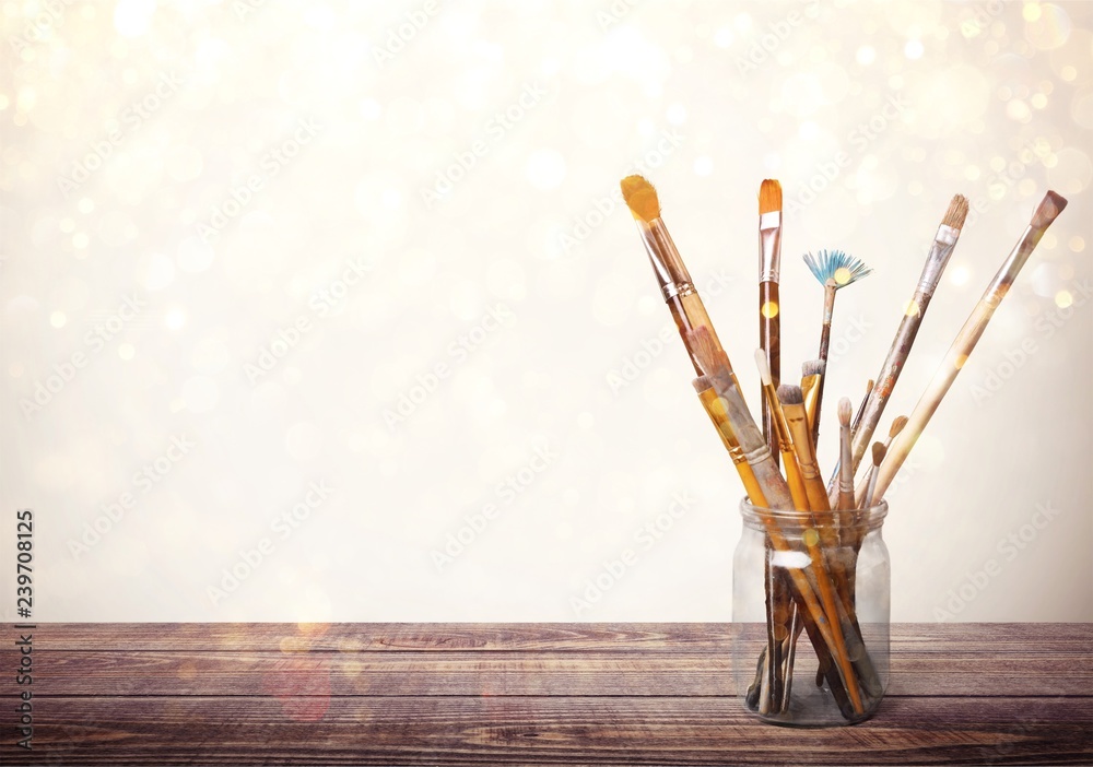 Brushes in glass jar isolated on table