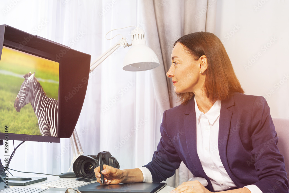 Female photographer retouching photos in office portrait