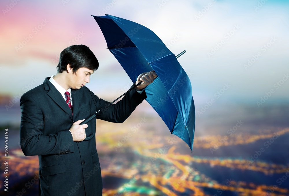 Portrait of  businessman with umbrella on background