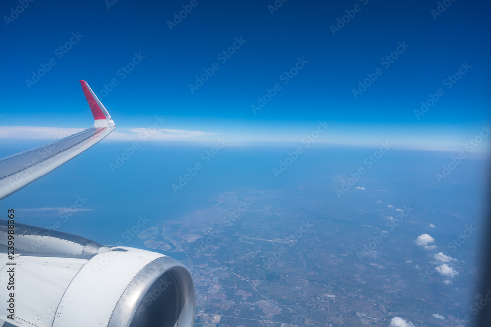 wing of airplane flying above the clouds