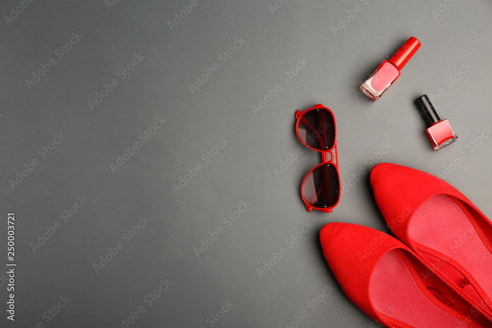 Composition with female shoes, cosmetics and sunglasses on grey background