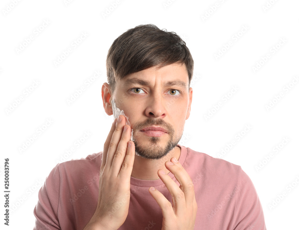 Handsome man with shaving foam on his face against white background