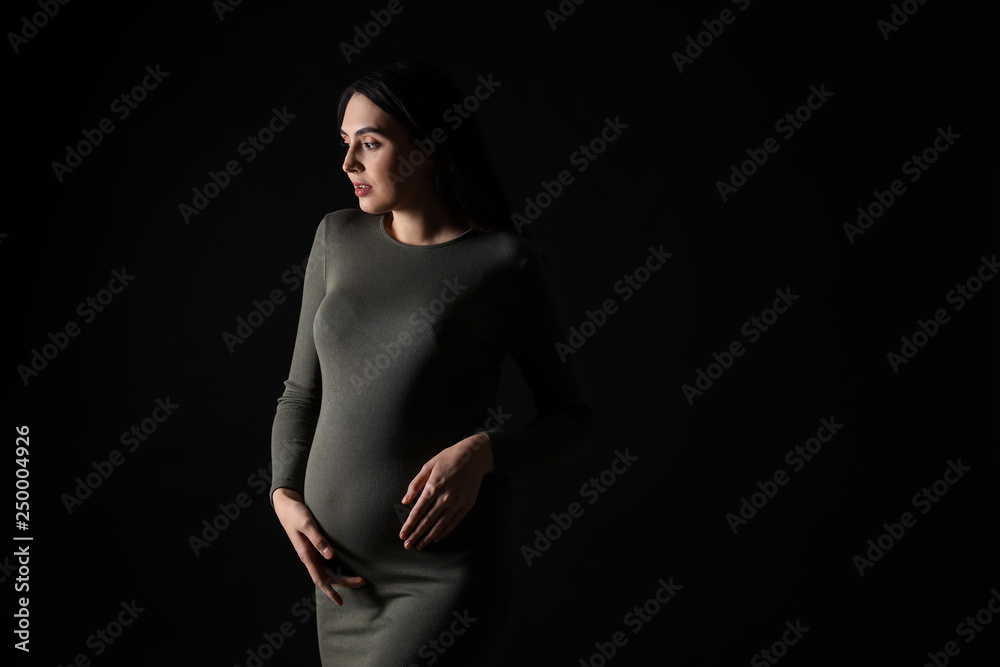 Portrait of beautiful pregnant woman on dark background