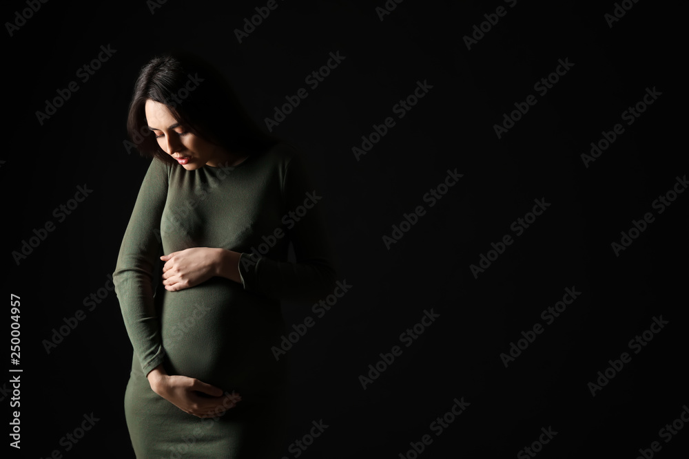 Portrait of beautiful pregnant woman on dark background