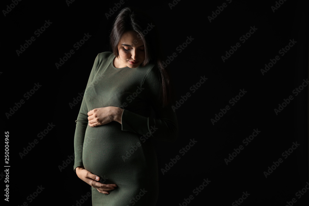 Portrait of beautiful pregnant woman on dark background