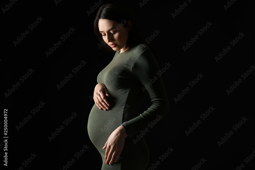 Portrait of beautiful pregnant woman on dark background