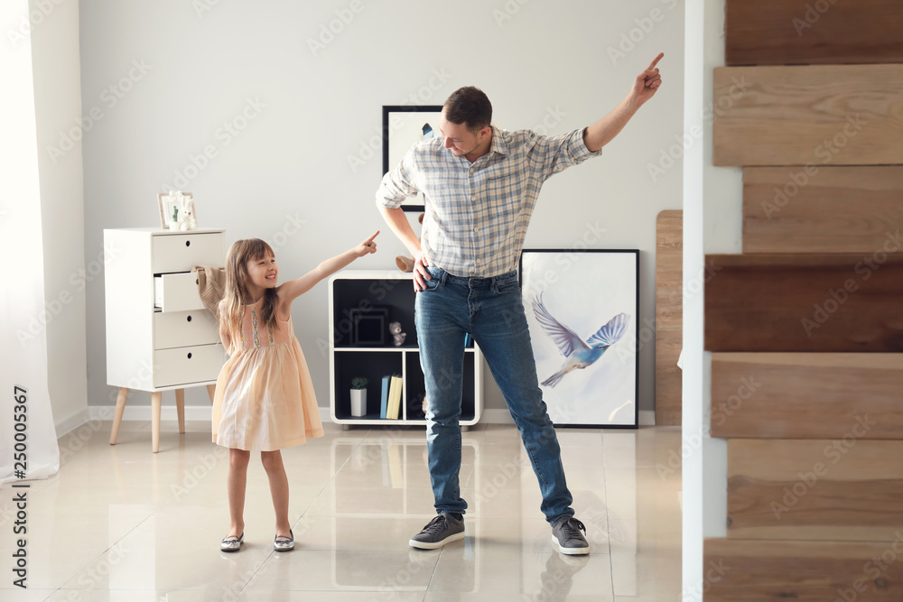 Father and his cute little daughter dancing at home