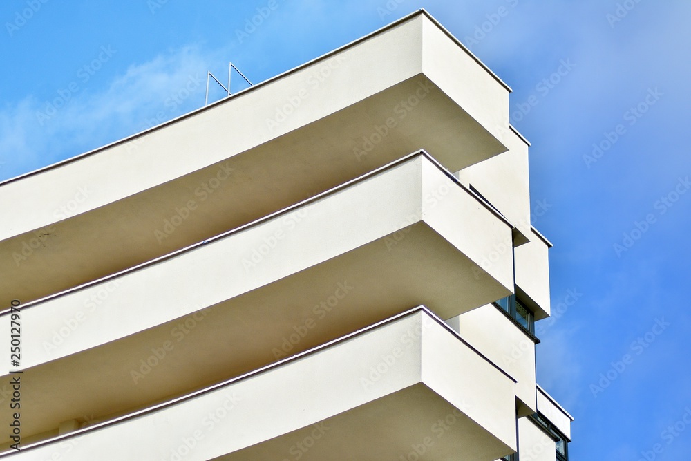 Modern white building with balcony on a blue sky