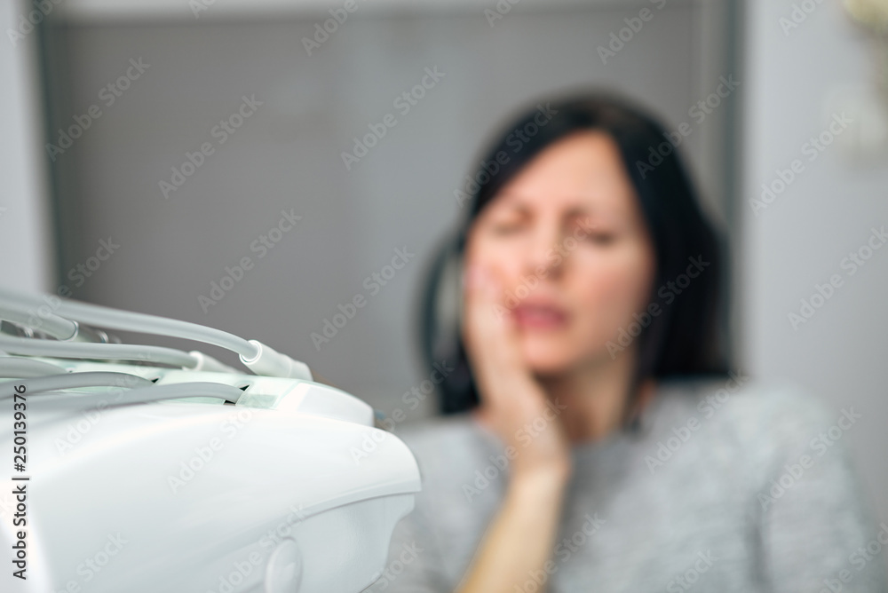 Medicine, dentistry and healthcare concept. Woman with tootache at dental clinic, focus on the foreg