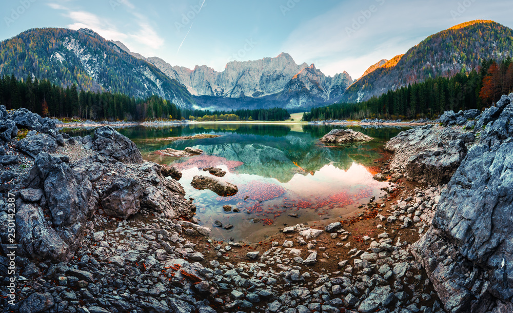 Colorful sunrise on Fusine lake. Picturesque autumn scene with Mangart peak on background. Julian Al