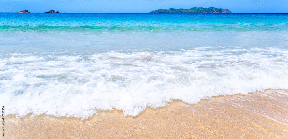 Beautiful amazing gold colored sandy beach with soft waves isolated with sunny blue sky. Concept of 