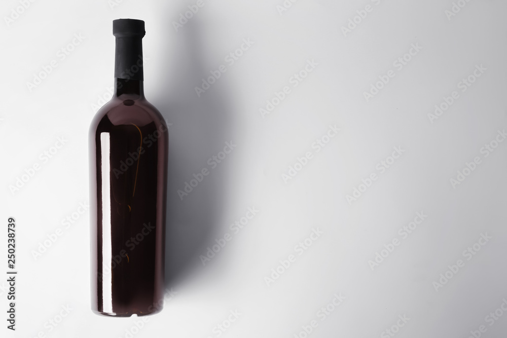 Bottle of tasty wine on light background