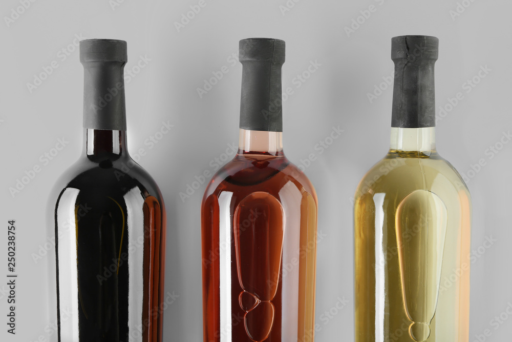 Bottles of tasty wine on light background