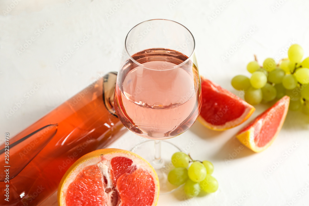 Tasty wine with fresh fruits on white table