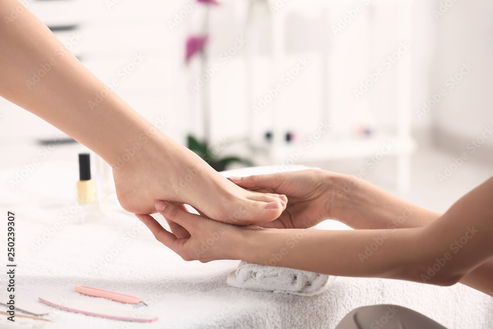 Young woman getting foot massage in beauty salon