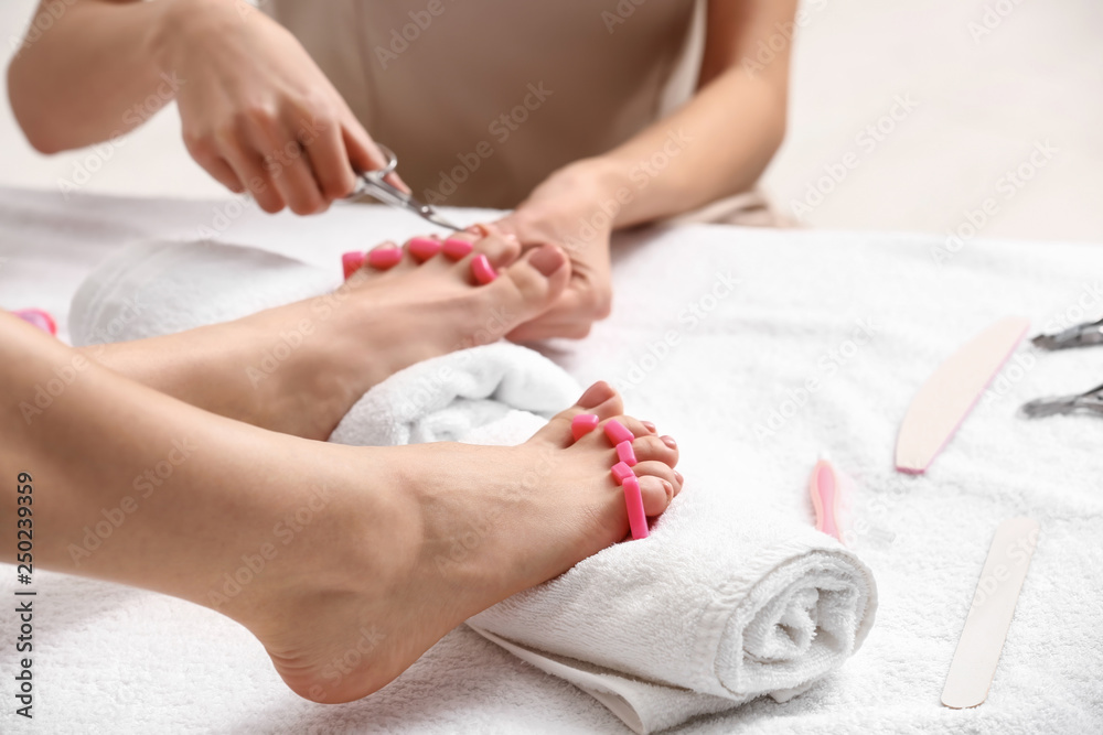 Young woman getting pedicure in beauty salon