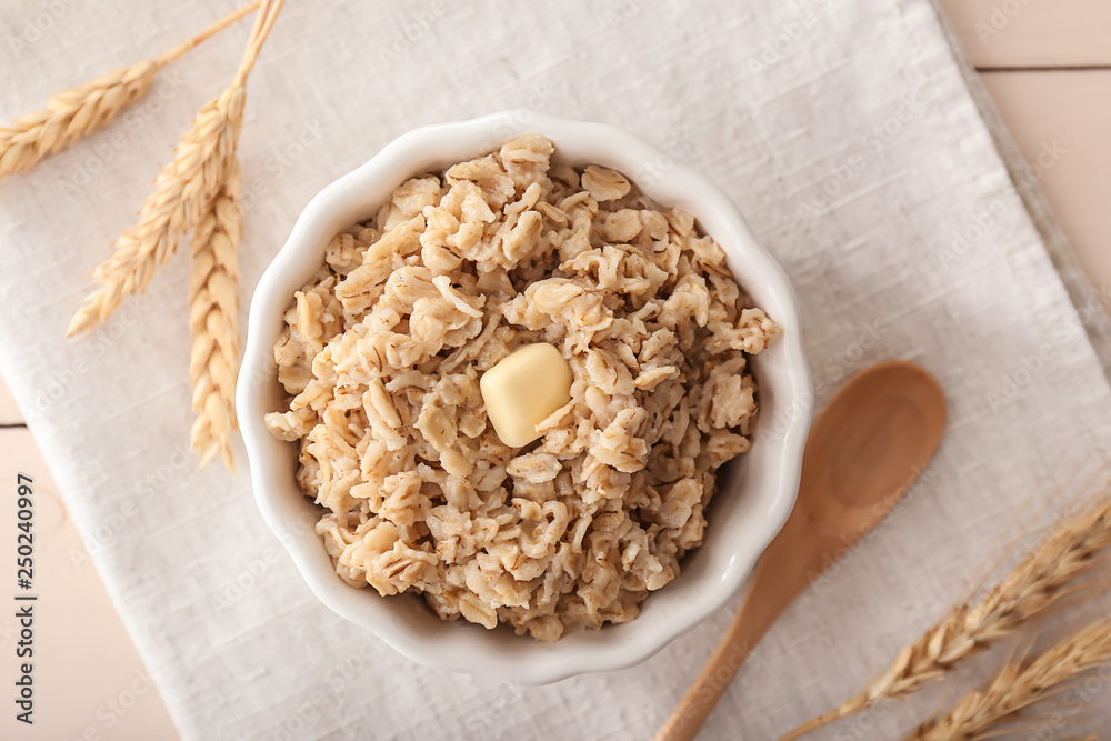 Bowl with tasty oatmeal on table