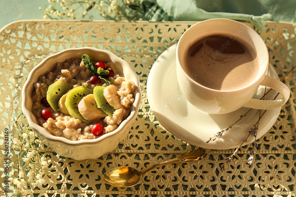 Bowl with tasty oatmeal and cup of coffee on table