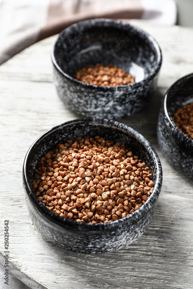 Bowls with raw buckwheat on table