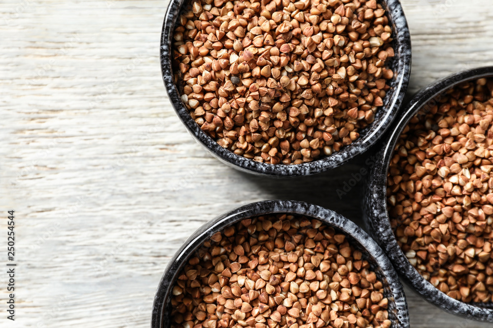 Bowls with raw buckwheat on table