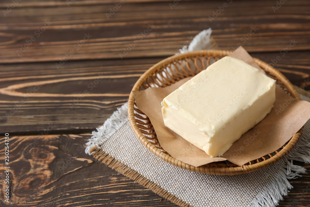 Plate with butter on wooden background