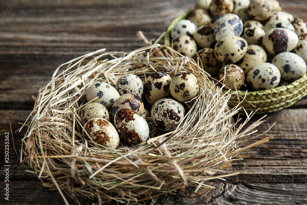 Nest with quail eggs on wooden table