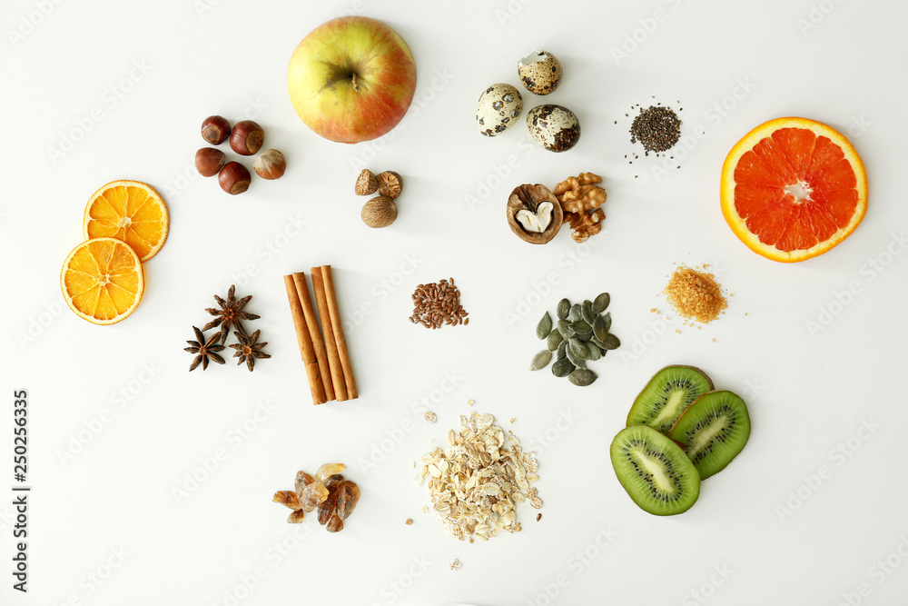 Raw oatmeal, fruits and spices on white background