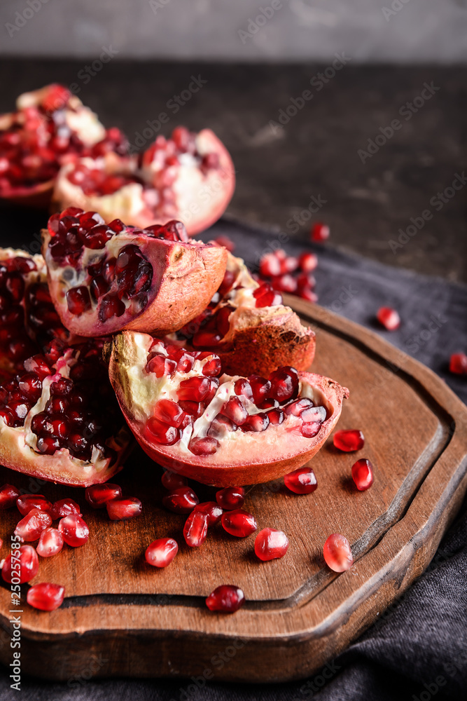 Board with ripe pomegranates on table