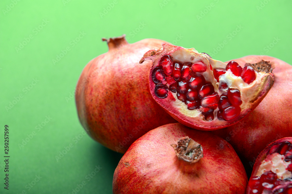 Ripe pomegranates on color background, closeup