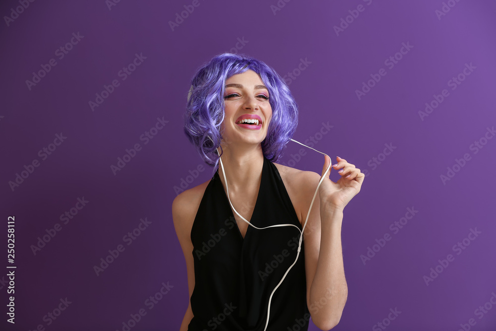 Beautiful young woman listening to music on color background