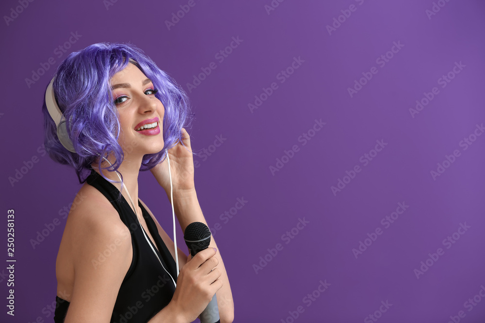 Beautiful young woman with microphone and headphones on color background