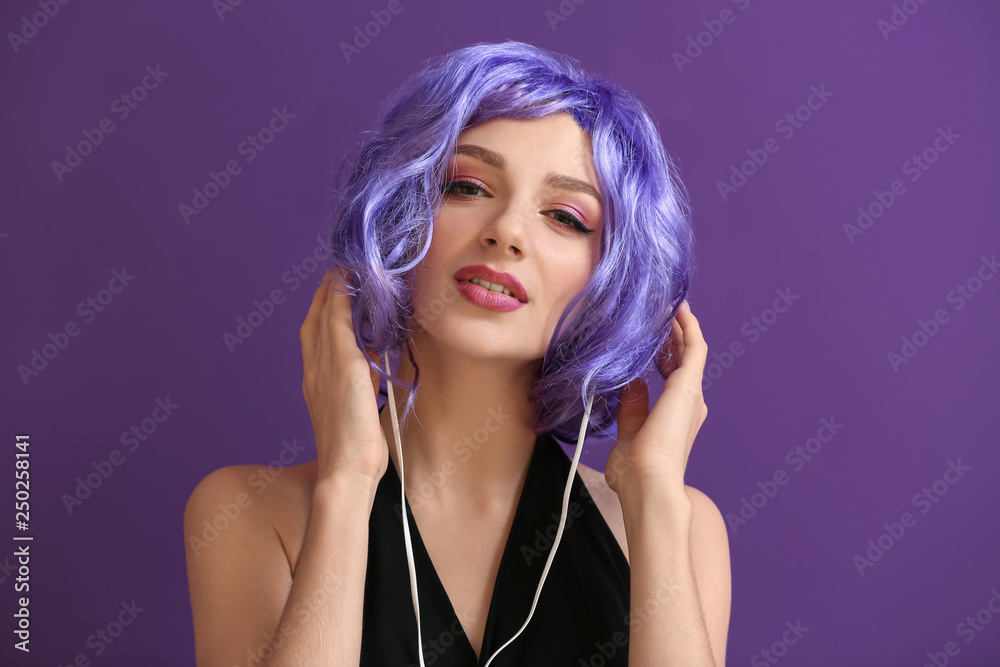 Beautiful young woman listening to music on color background