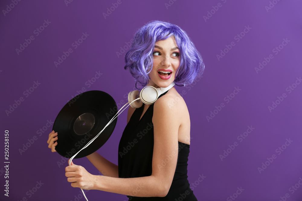 Beautiful young woman with vinyl disk and headphones on color background