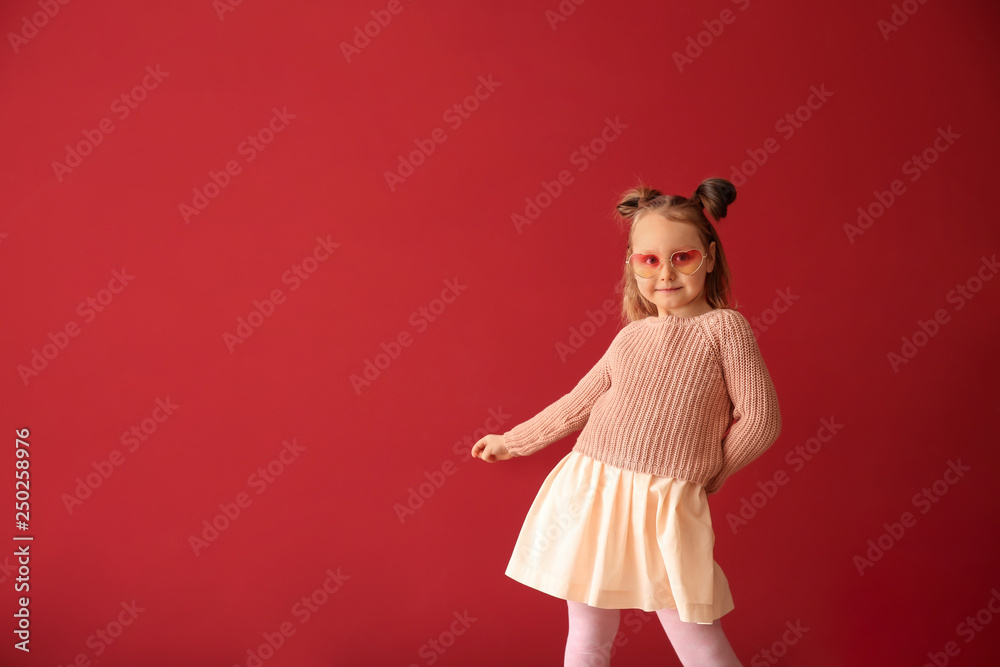 Fashionable little girl on color background