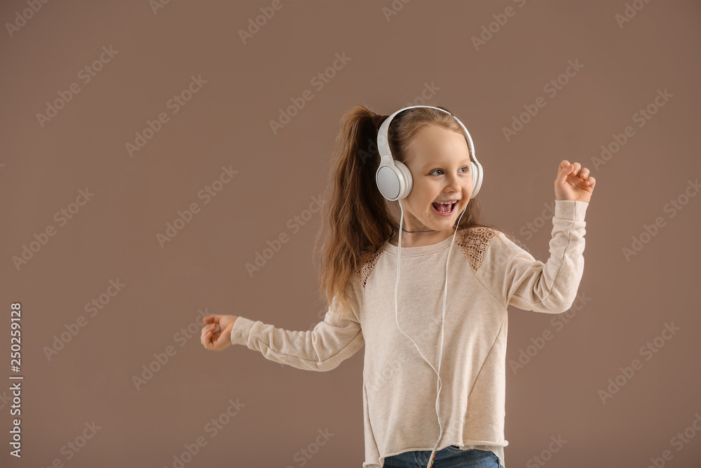 Cute little girl listening to music on color background