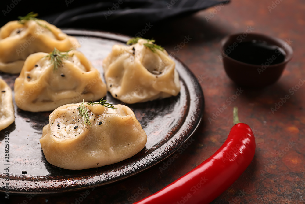 Plate with tasty dumplings on table, closeup