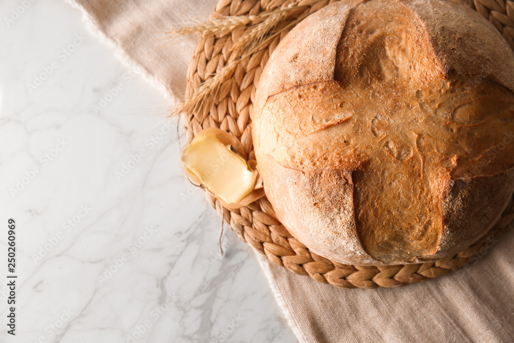 Loaf of fresh bread on light background