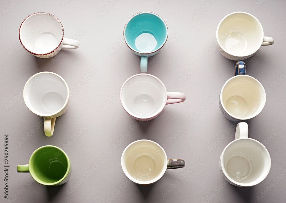 Colorful empty cups on light background